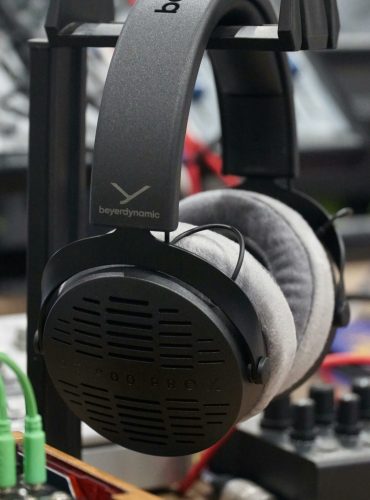 Close-up of professional wireless studio headphones on a stand indoors.
